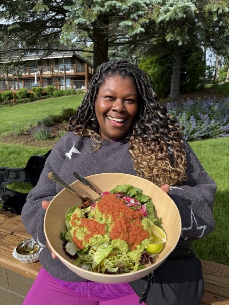 Vegan Wellness Retreats — a smiling guest holding a colorful plant-based platter
