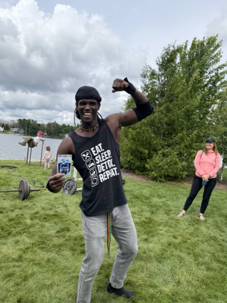 Vegan Wellness Retreats — a guest flexing and smiling by the lake