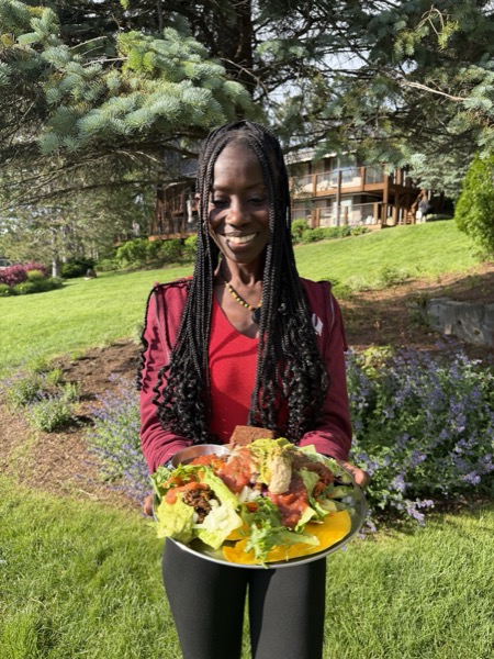 Vegan Wellness Retreats — a smiling guest holding a loaded plant-based plate