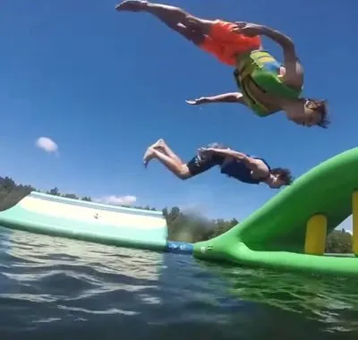 Guests flipping off the water inflatables at Timber Wolf Lake