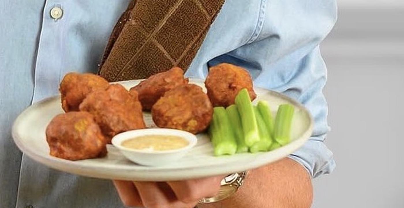 A plate of baked BBQ cauliflower wings with celery and a dip