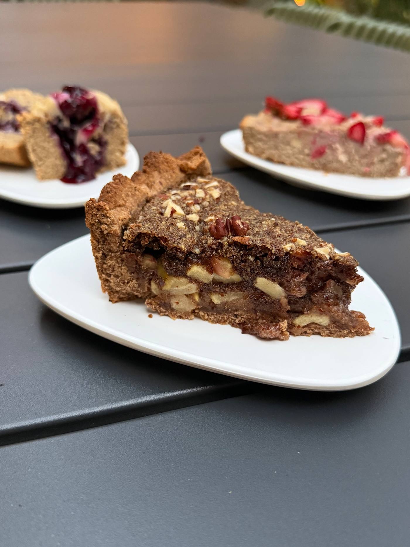 Three slices of whole-food plant-based cake and pie on plates at the dessert tasting
