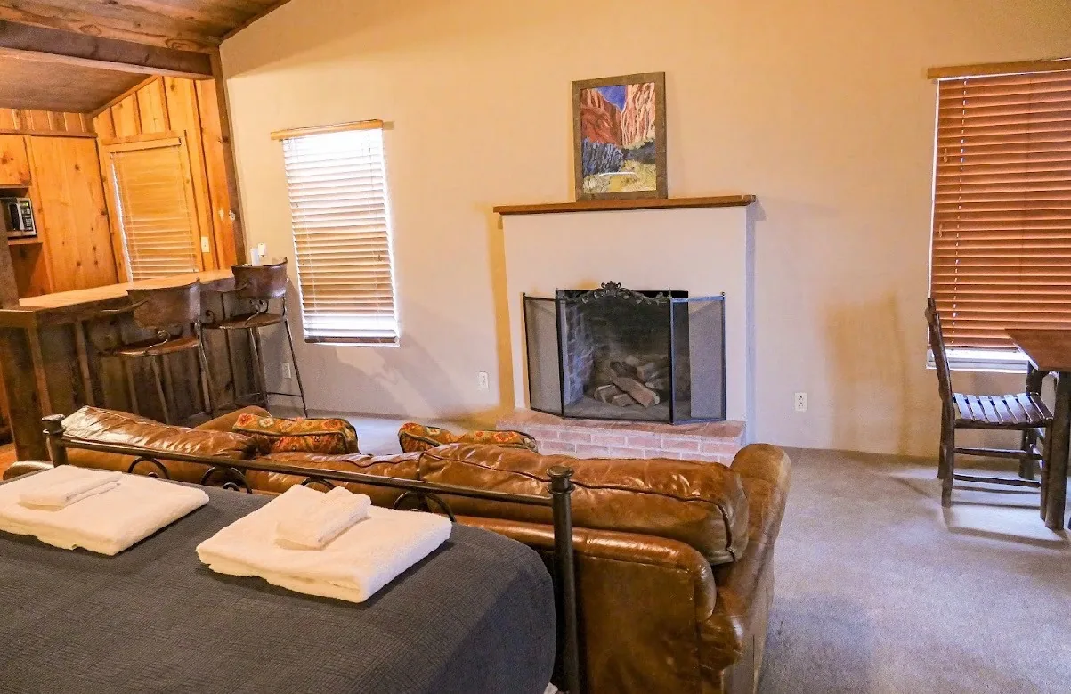The Homestead Private Cabin living room with fireplace, sofas and kitchen bar