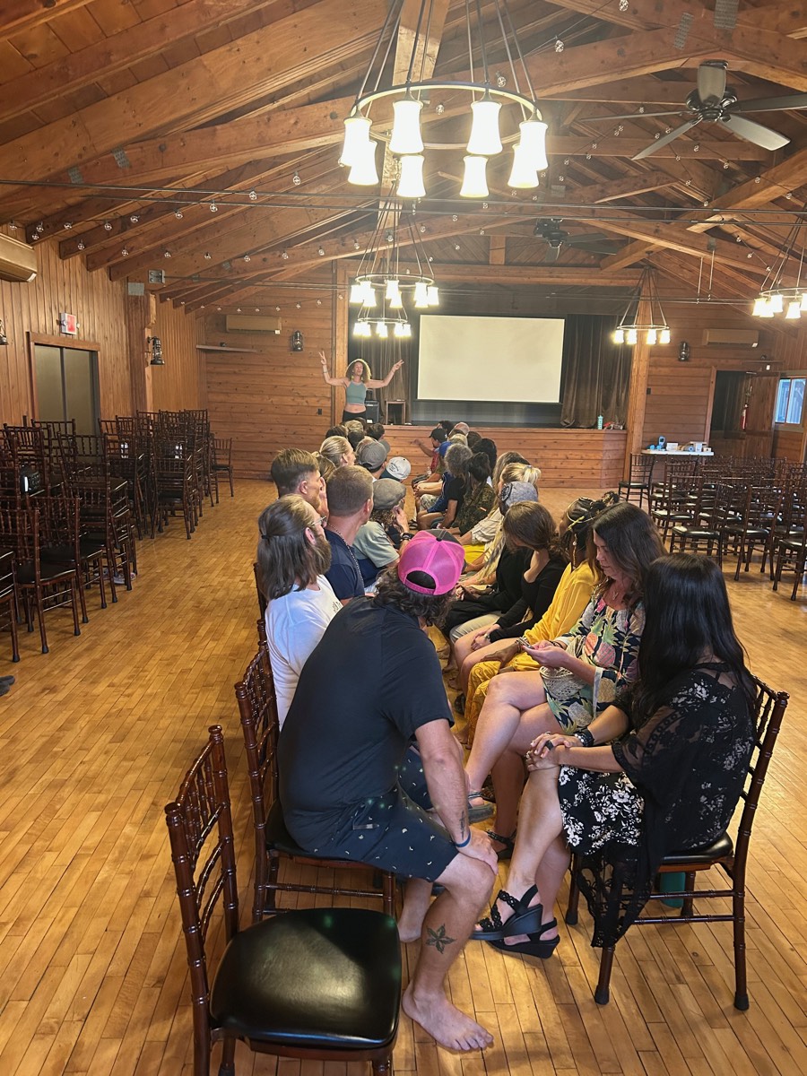 A host facilitating Speed Dating night for a full room of guests in the great hall